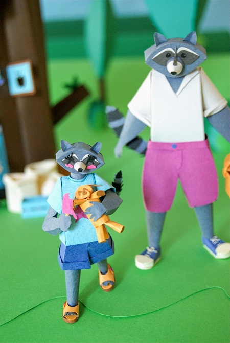 Paper art - Detail of the young raccoon girl with her ice cream and her stuffed dog. Miniatures.