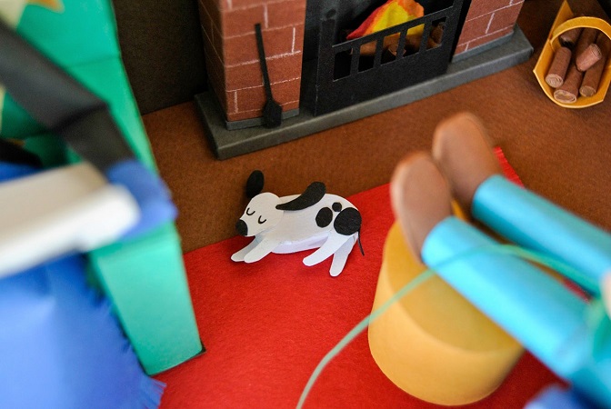 Paper art - Little dog dozing by the fireplace. Diorama detail. Miniature.