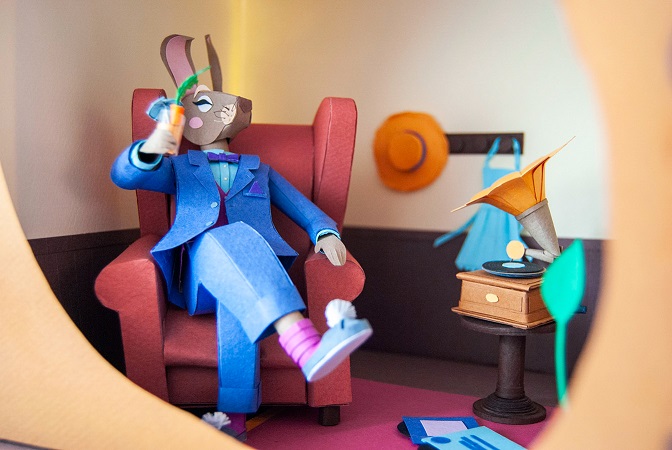 Paper art - Cool paper hare listening to music with a gramophone inside her elegant burrow.