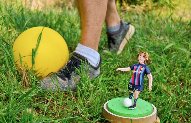 Paper art - The birthday present next to the birthday boy's feet. Soccer / football player and his portrait dressed as FC Barcelona.