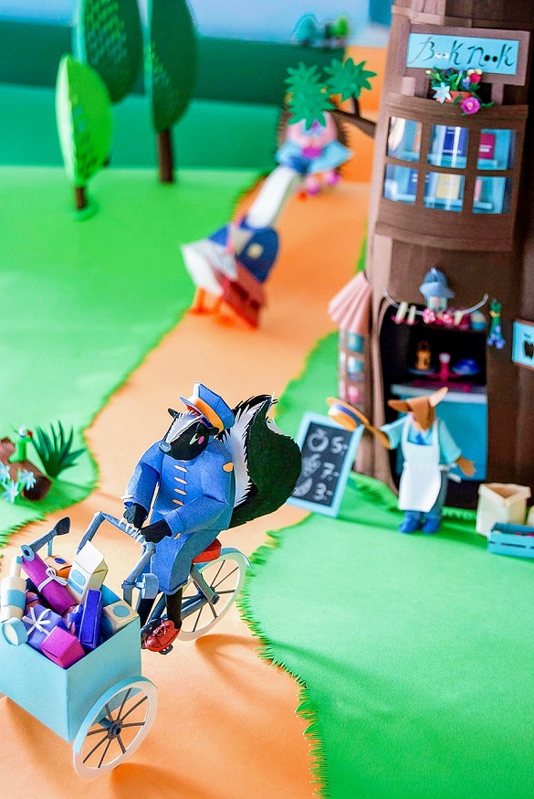 Paper art - General view of the skunk leaving the grocery store on his tricycle loaded with orders. Diorama.