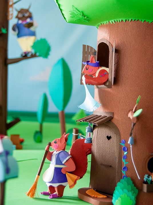 Paper art - The pair of house-proud squirrels carefully clean their beautiful house tree full of flowers and lovely details. Diorama.