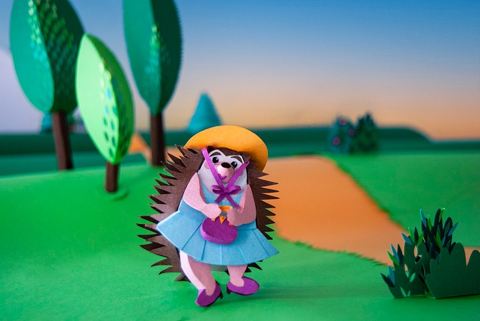 Paper art - The hedgehog likes to walk along the path through the forest at dusk. Paper sculpture.