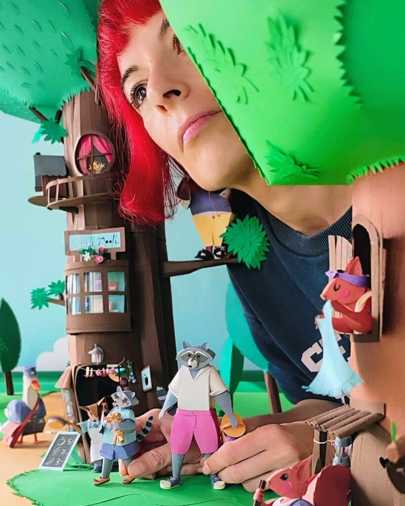 Paper artist - Self-portrait between two paper trees and a few characters from diorama "Life".