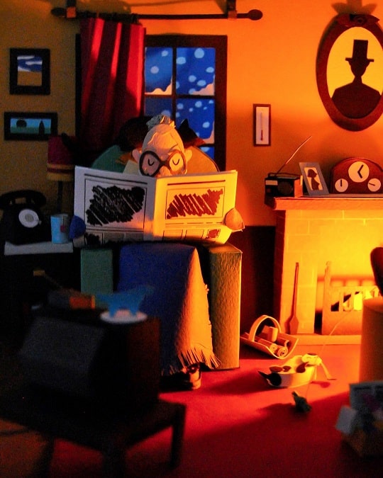 Paper Art - Grandma reads the news by the fireplace while the snowstorm. Paper diorama.