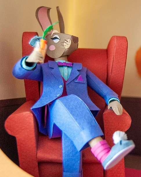 Paper art - Hare seated in an armchair with a carrot cocktail. Paper sculpture.