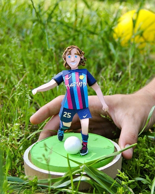 Paper art - The birthday boy holds his miniature portrait dressed in the Barça kit.