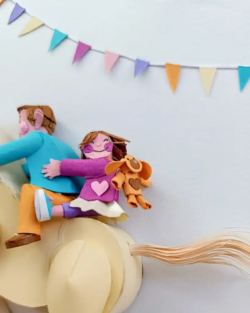 Paper Art - Detail of smiling girl hugging her brother on the back of a horse. Papercrafts.